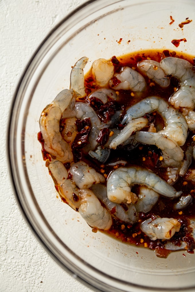 raw shrimp in a bowl with marinade. 