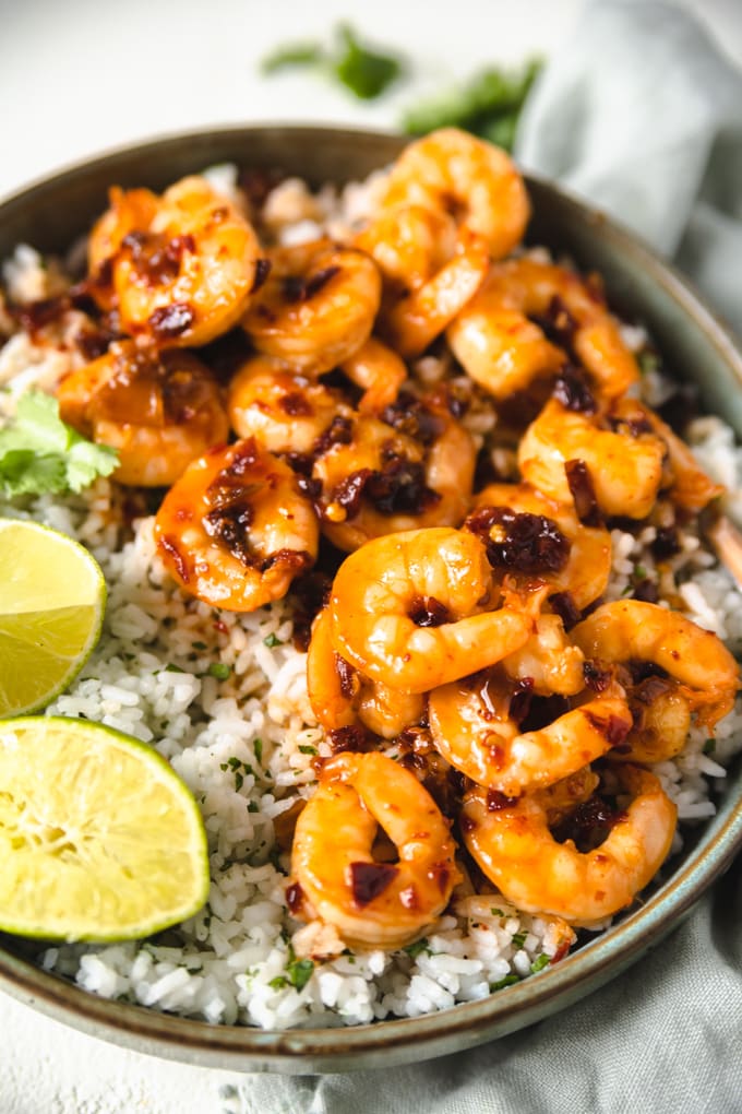 sauce on shrimp with lime and rice in a bowl.