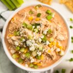 a bowl of buffalo chicken dip with corn and blue cheese on top.