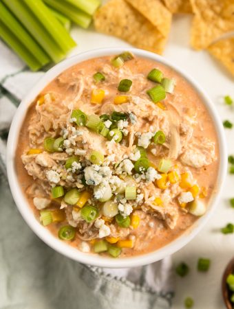 a bowl of buffalo chicken dip with corn and blue cheese on top.