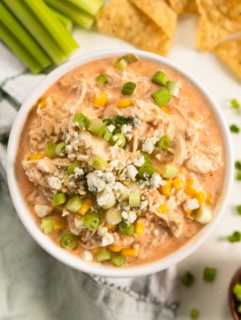 a bowl of buffalo chicken dip with corn and blue cheese on top.