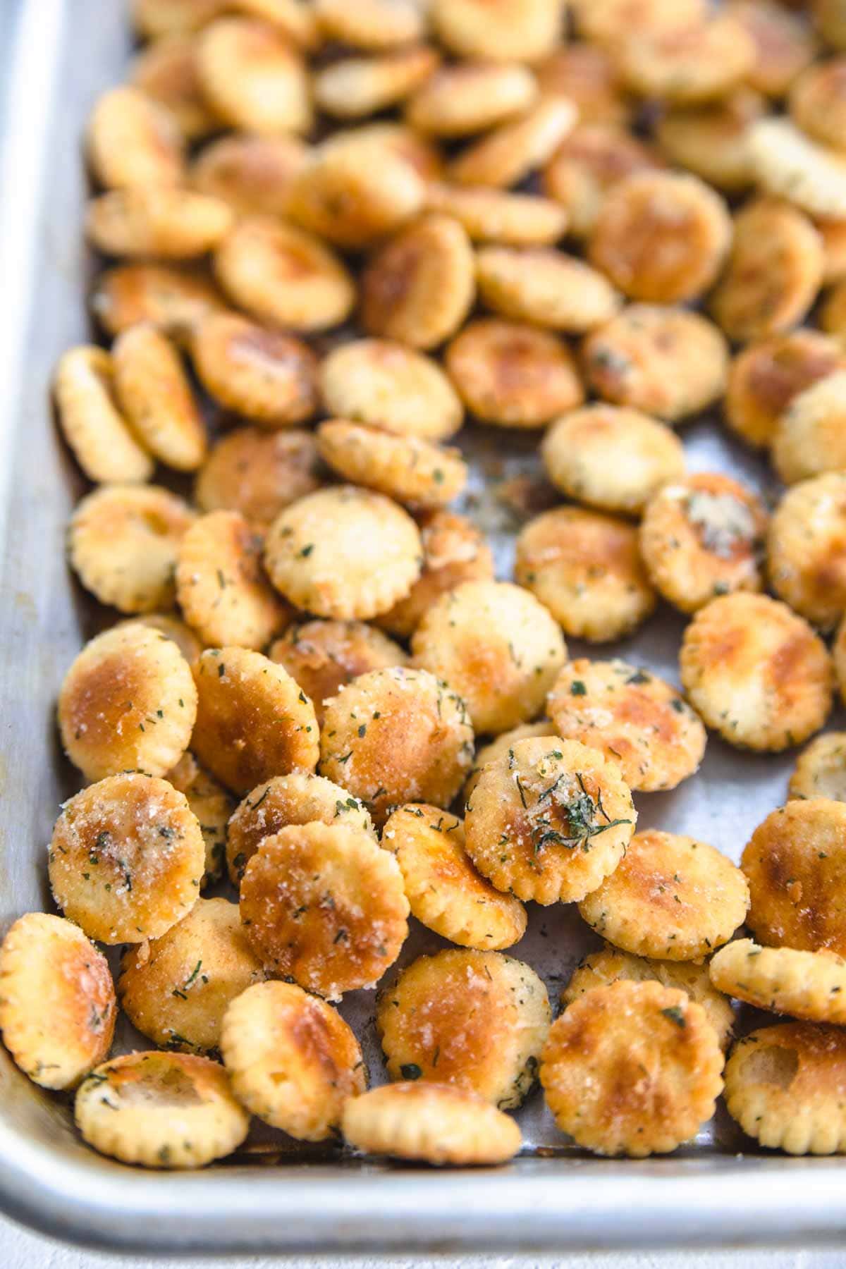 ranch seasoning on oyster crackers on a baking sheet. 