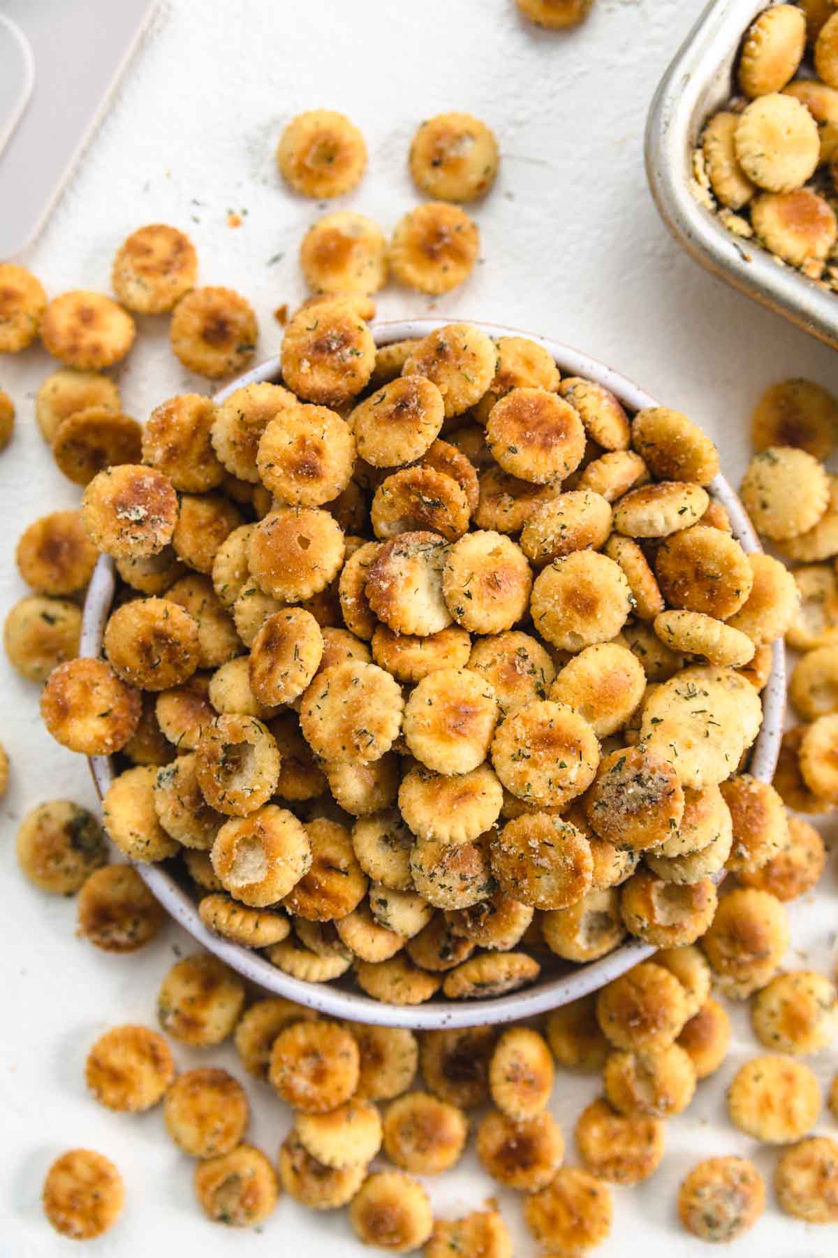 baked ranch flavored oyster crackers overflowing out of a bowl.