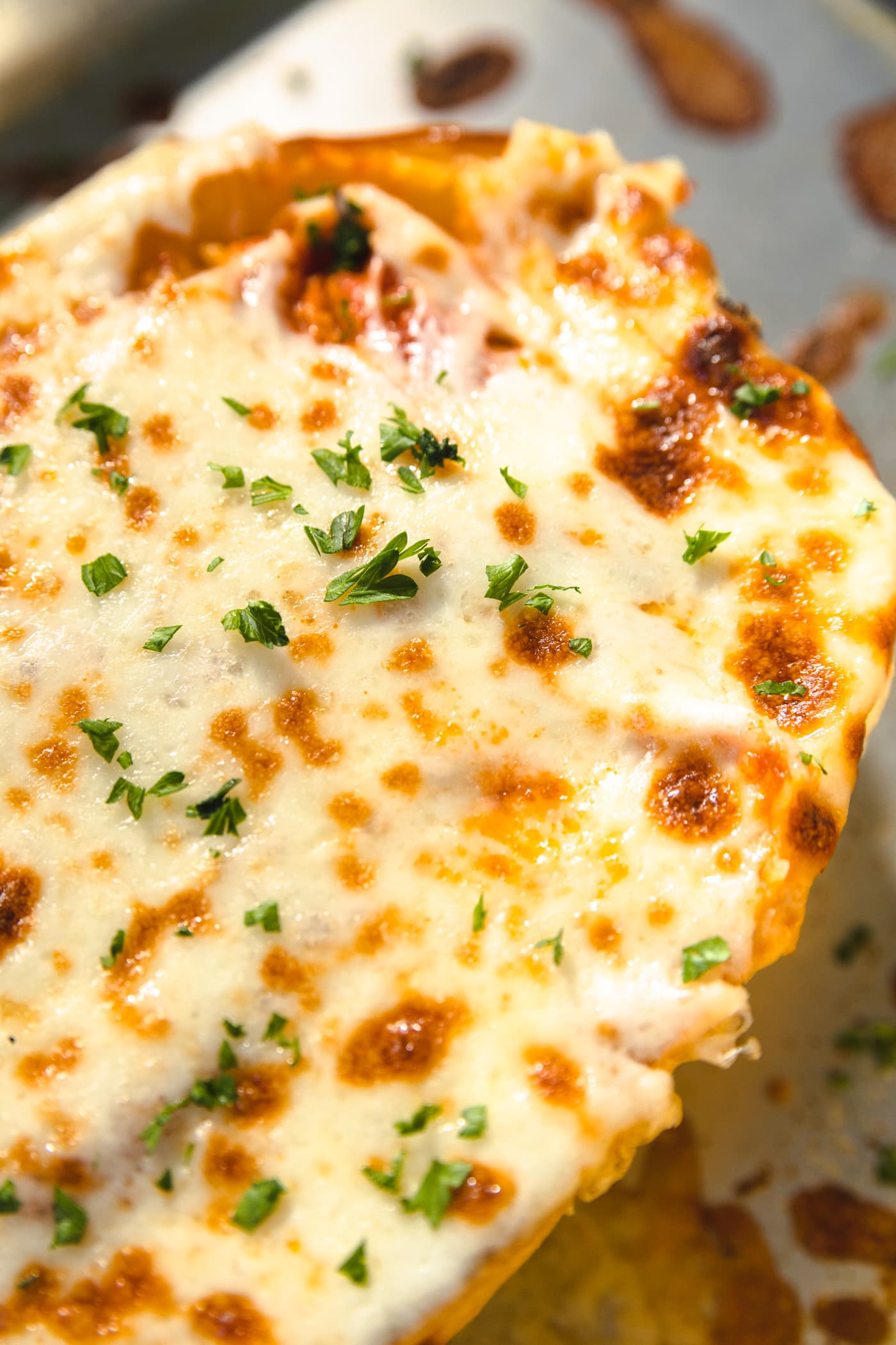 melted cheese on top of a squash with basil