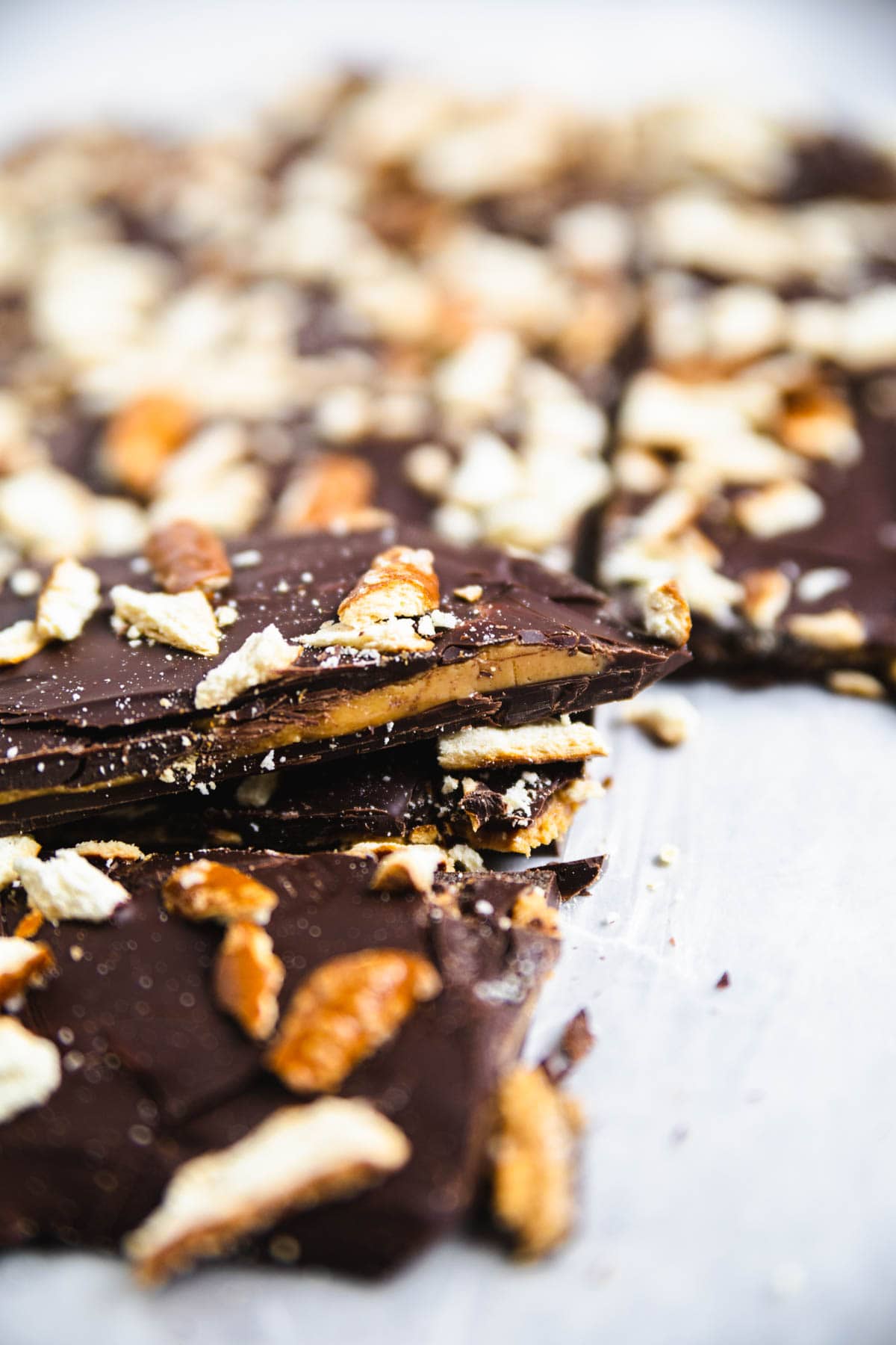 a baking sheet with broken pieces of bark with crushed pretzel on top.