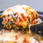 a slice of vegetarian lasagna being lifted from a slow cooker with a spatula.