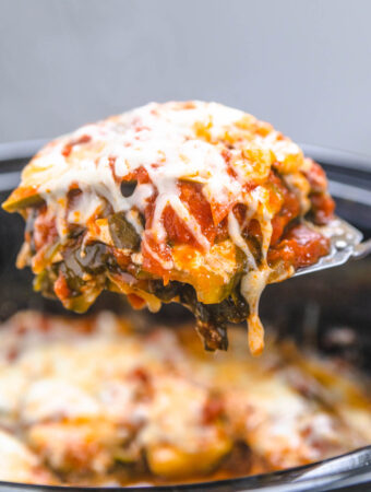 a slice of vegetarian lasagna being lifted from a slow cooker with a spatula.