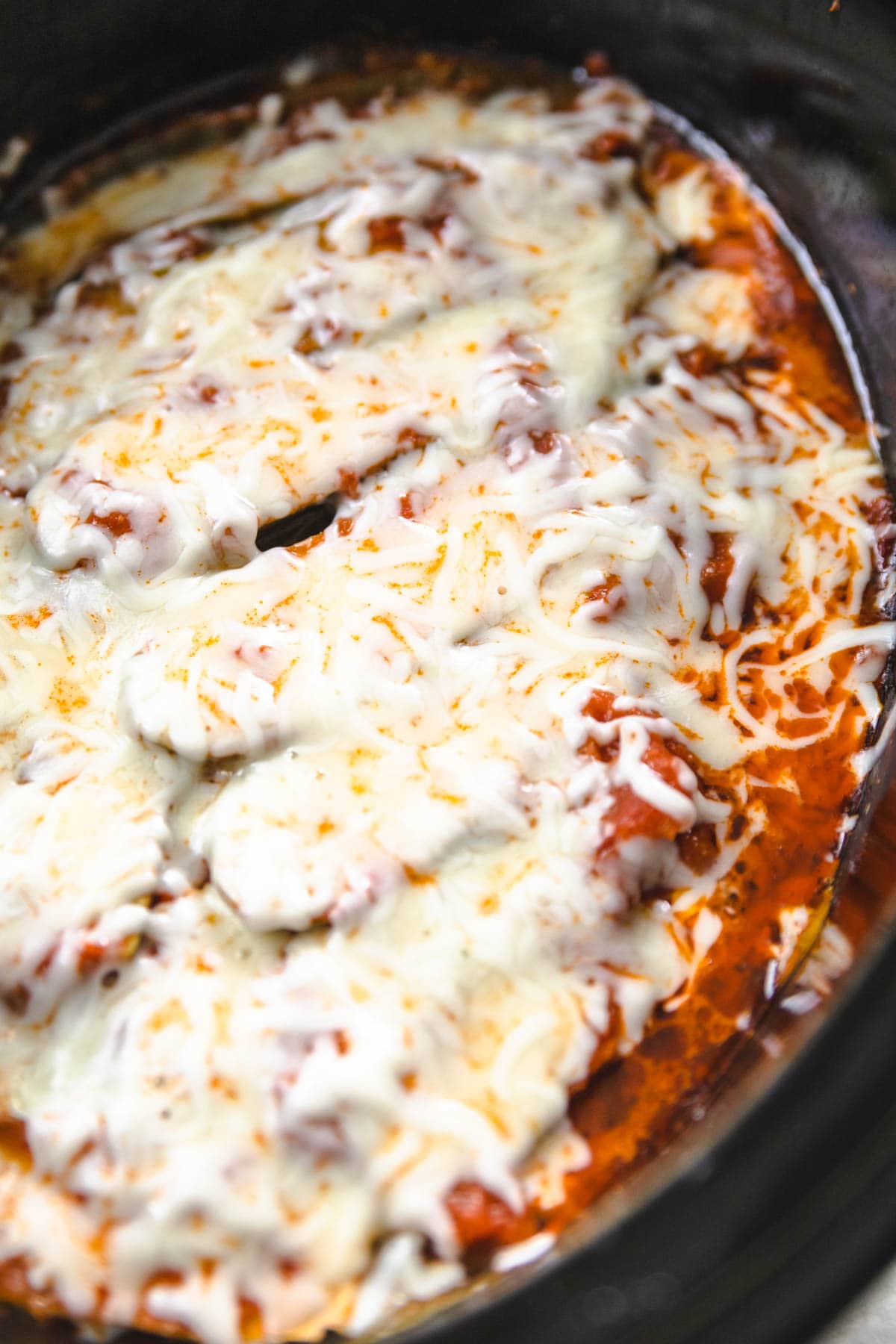 The top layer of the crockpot lasagna with mozzarella cheese on top of the zucchini noodles.