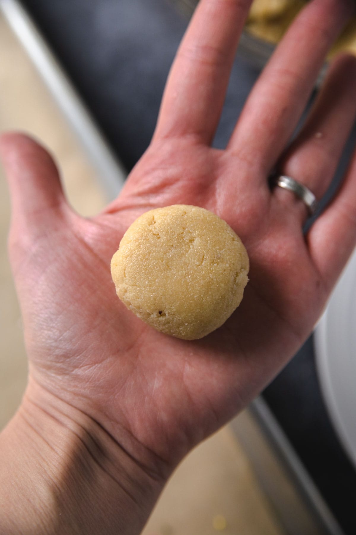 A dough ball on the inside of a hand to show measure. 