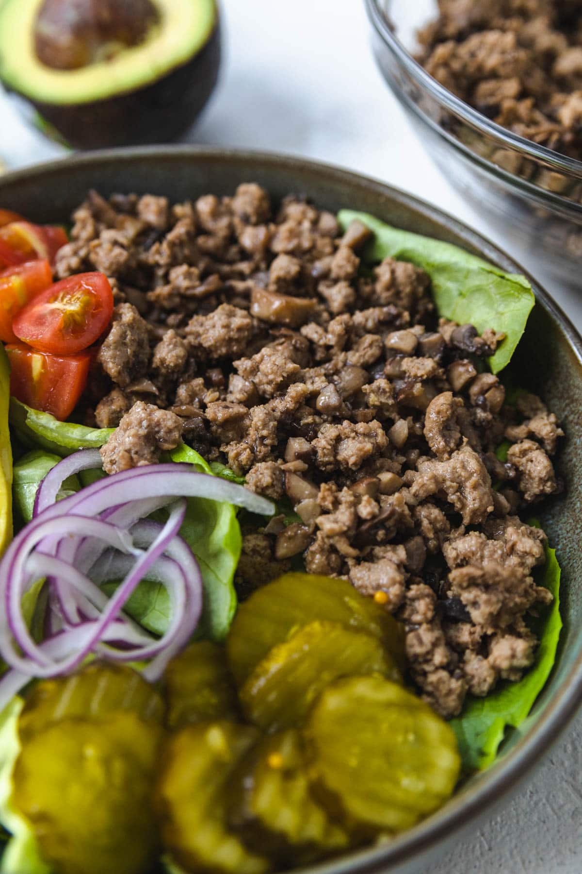 GROUND TURKEY WITH CHOPPED PORTOBELLO MUSHROOM IN A BOWL WITH BURGER BOWL TOPPINGS.