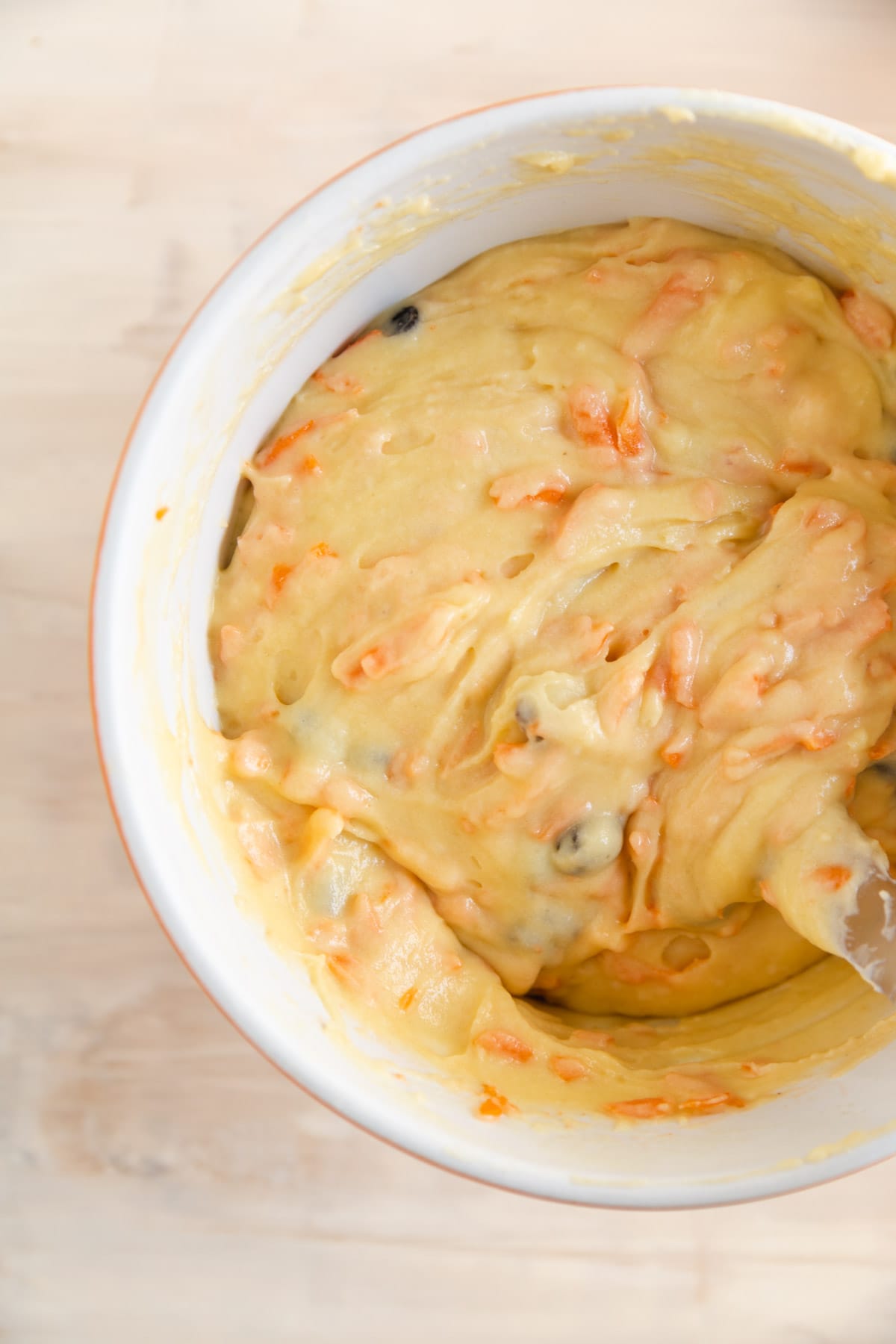 Carrot cake bread batter in a bowl with a spatula. 