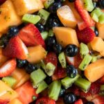 Assorted mixed fruit salad in a bowl with dressing.