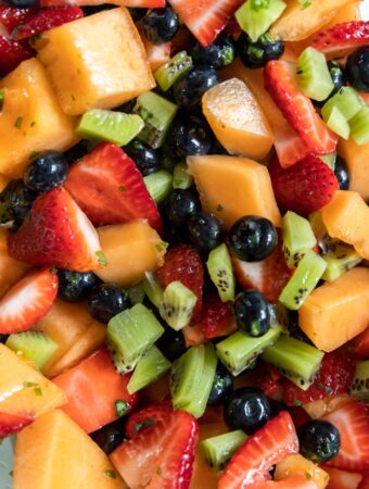 Assorted mixed fruit salad in a bowl with dressing.