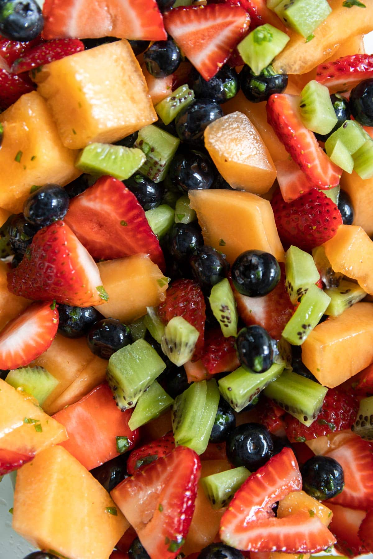 Assorted mixed fruit salad in a bowl with dressing.